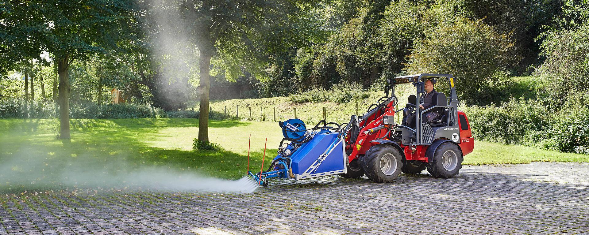 Weidemann Hoftrac/farm loader 1280 canopy with high-pressure cleaner in action