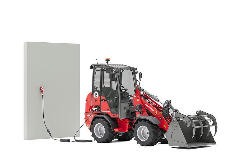 Weidemann Hoftrac 1290e mit Greifschaufel im Studio an einer Ladesäule