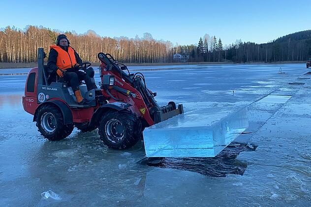 Weidemann Hoftrac 1250 im Einsatz mit einer Palettengabel auf dem ein Eisblock liegt