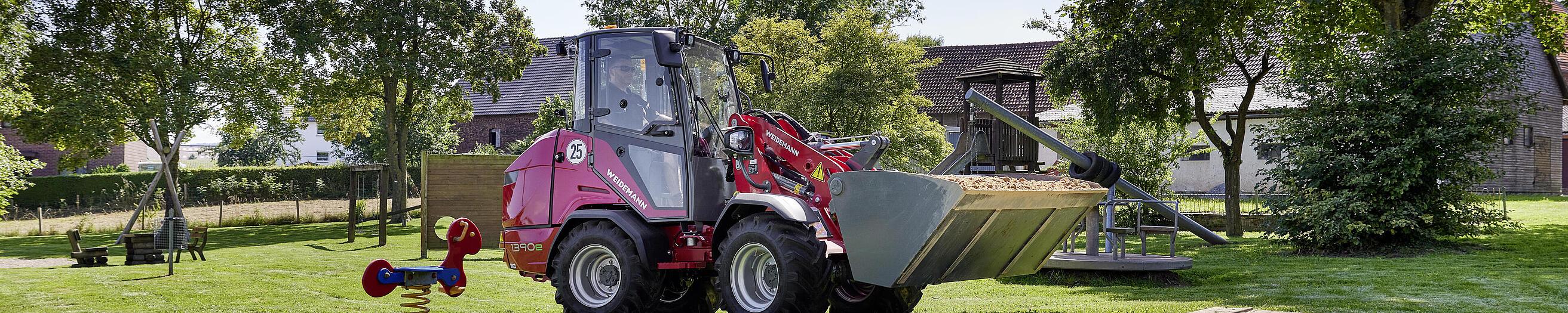 Weidemann Hoftrac 1390e mit Kabine auf einem Spielplatz