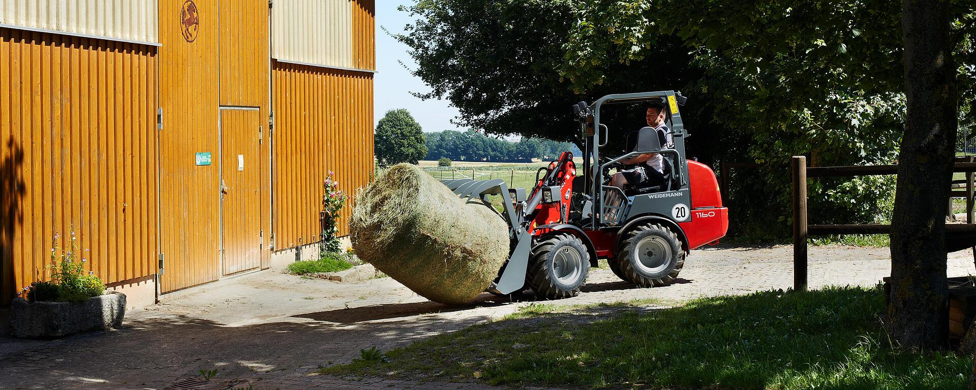 Weidemann Hoftrac/farm loader 1160 canopy with grab and fork in action