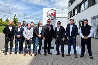Gruppe von Personen steht vor Gebäude