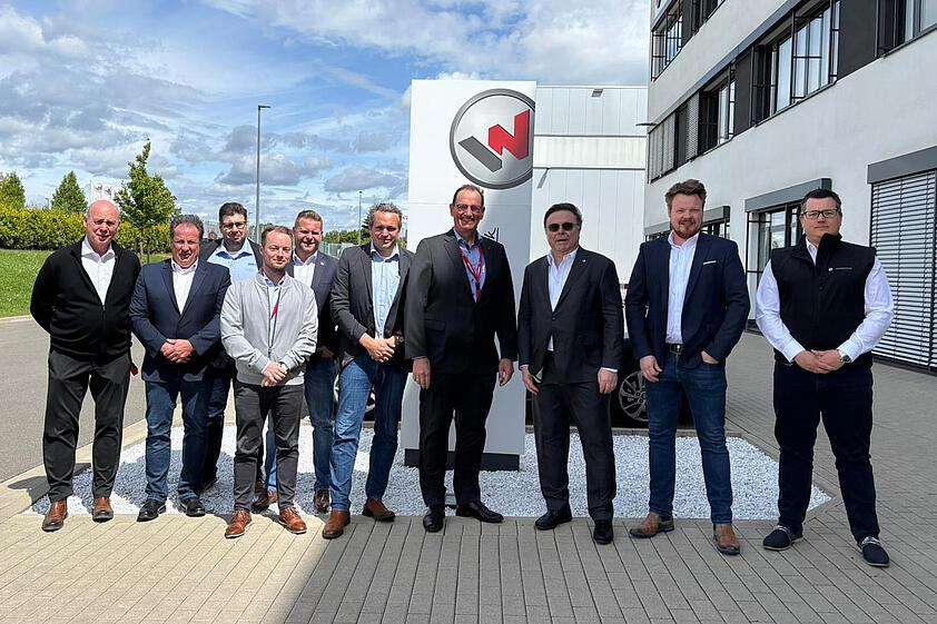 Gruppe von Personen steht vor Gebäude