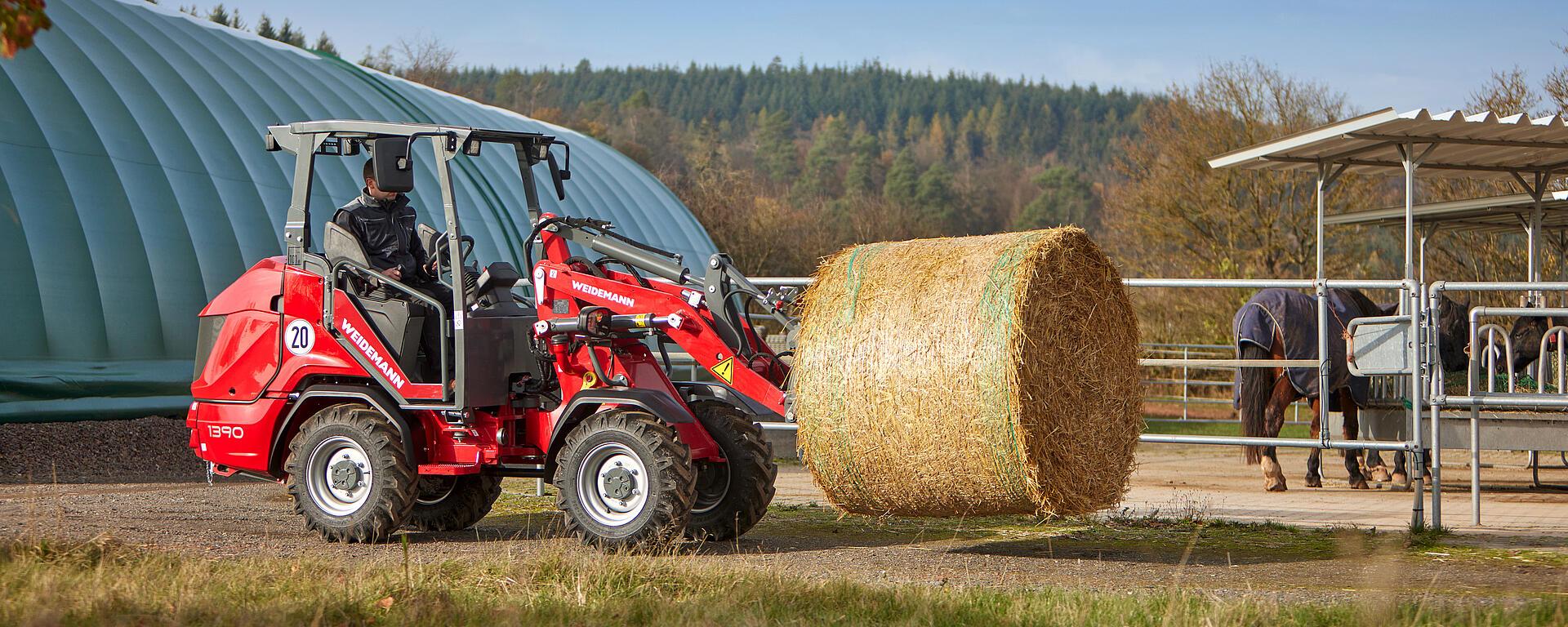 Weidemann Hoftrac/farm loader with bale spike in action