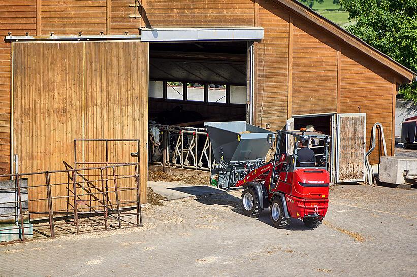 Weidemann Hoftrac 1290e im Einsatz auf einem landwirtschaftlichen Betrieb mit einem Einstreugerät