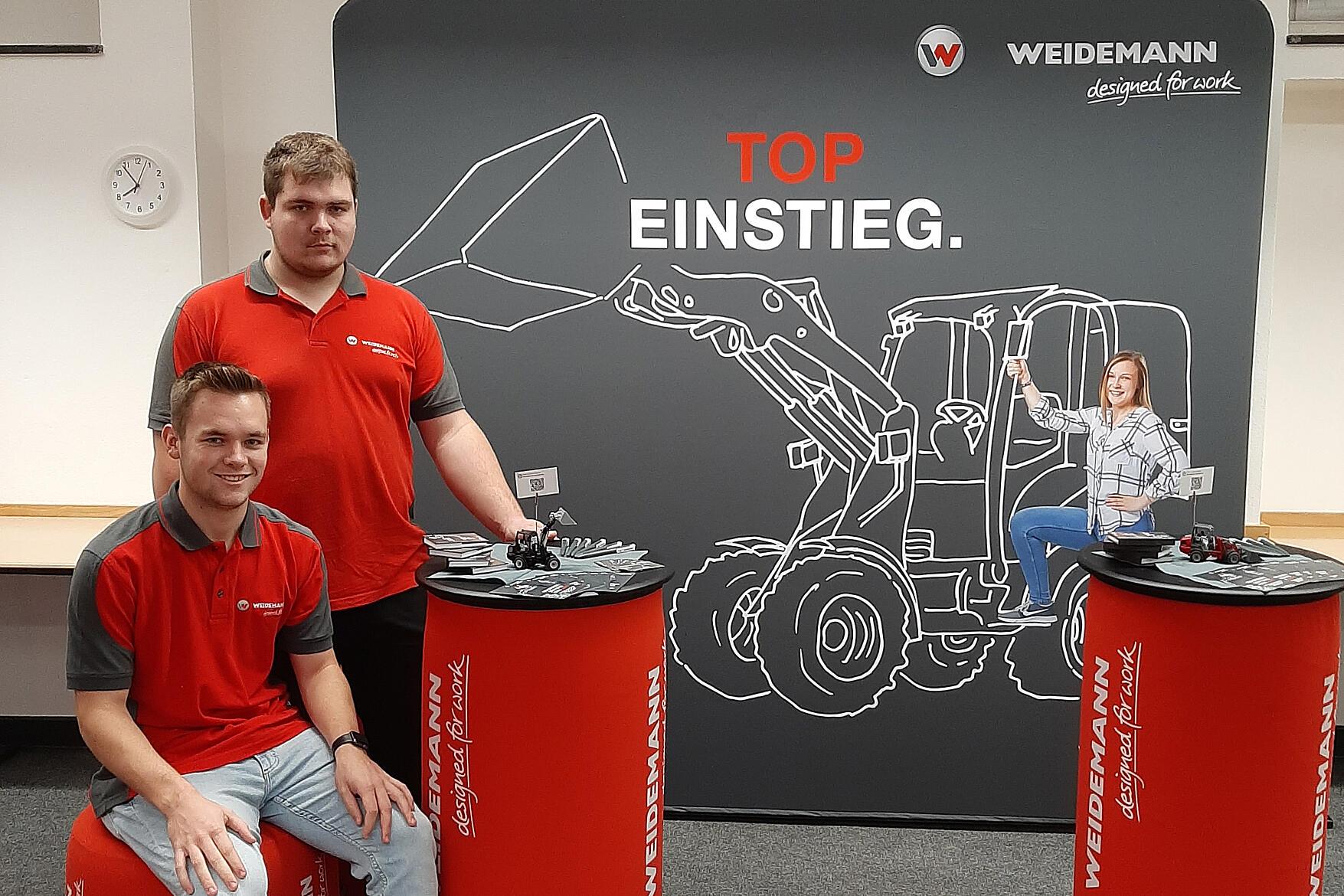 Zwei Weidemann Auszubildende vor einem Banner auf einer Ausbildungsmesse